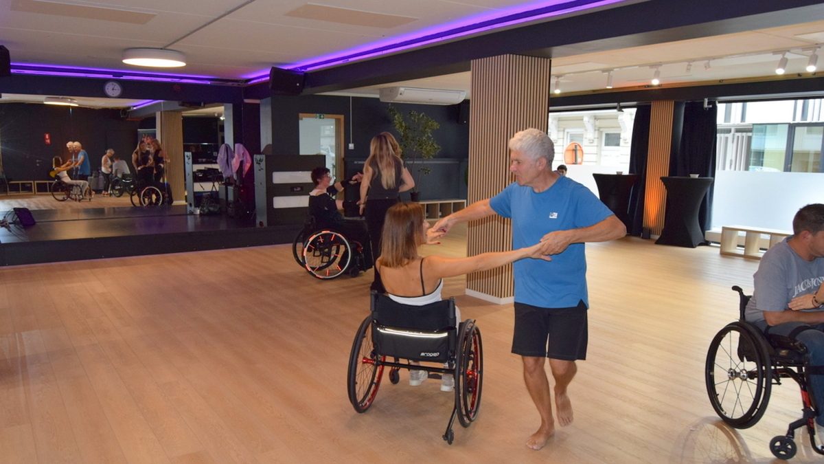 Cours de cyclodanse au Studio 28, Bruxelles : une danseuse en fauteuil roulant tourne avec son partenaire.